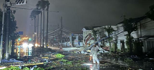 台風１０号に伴う突風で道路上には瓦や木々が散乱.電柱も倒れ一帯が停電している＝２９日午前１時１１分、宮崎市東大淀１丁目