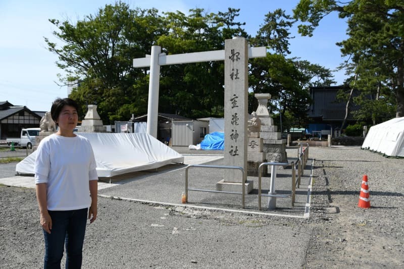 能登半島地震で、重蔵神社の損壊した鳥居の前に立つ禰宜の能門亜由子さん＝６月１２日、石川県輪島市