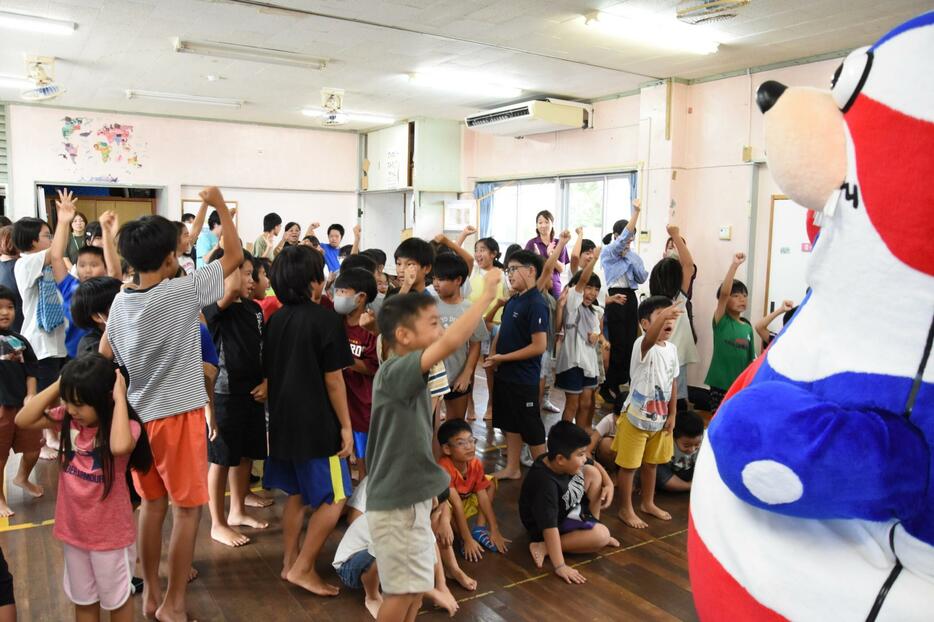 ゴーディー（右）とクイズなどで盛り上がる子どもたち＝２０日、石垣市登野城のとのすく児童館