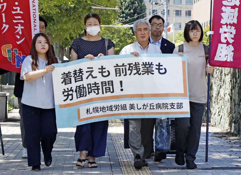 制服への着替え時間などを巡り、札幌地裁へ提訴に向かう原告ら＝15日午前、札幌市