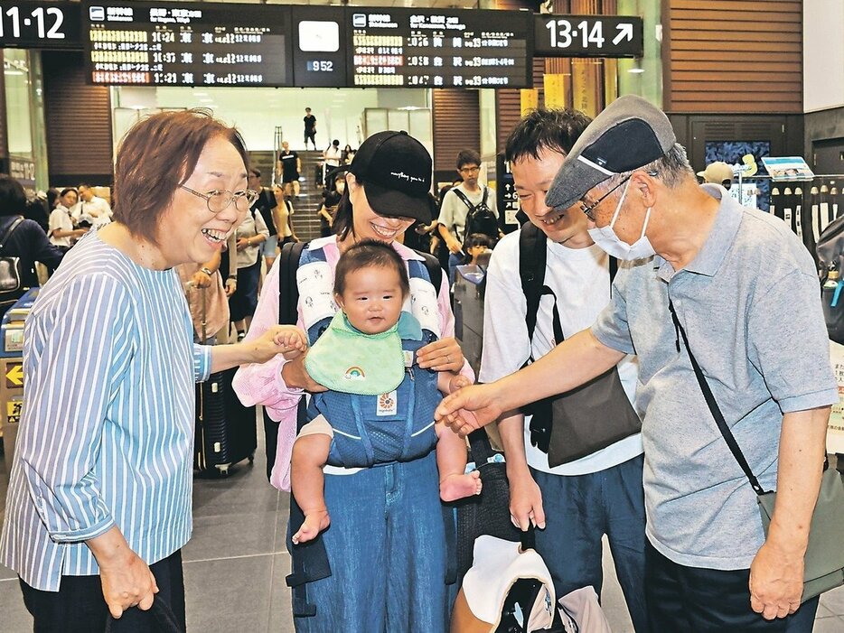 帰省した子どもと初孫の来県を喜ぶ祖父母＝富山駅