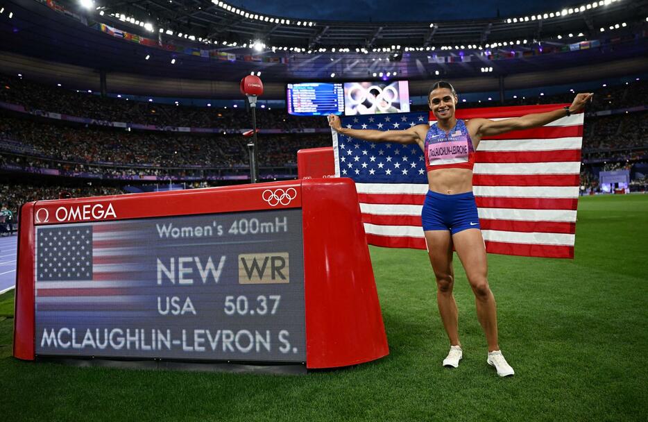 陸上女子400m障害を世界新で制し、電光掲示板の横でポーズをとるシドニー・マクラフリンレブロニ＝8日、パリ郊外（ロイター＝共同）