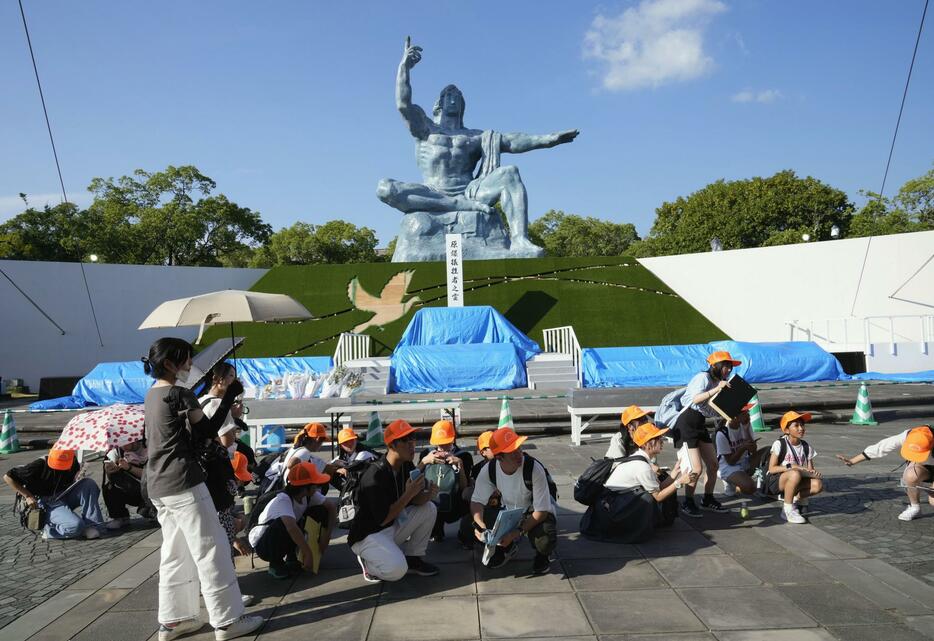 緊急地震速報が鳴り、地面にしゃがみこむ人たち＝8日午後4時44分、長崎市の平和公園