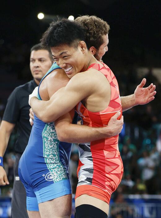 男子フリー74キロ級決勝で敗れ、ウズベキスタン選手（左）と健闘をたたえ合う高谷大地＝パリ（共同）