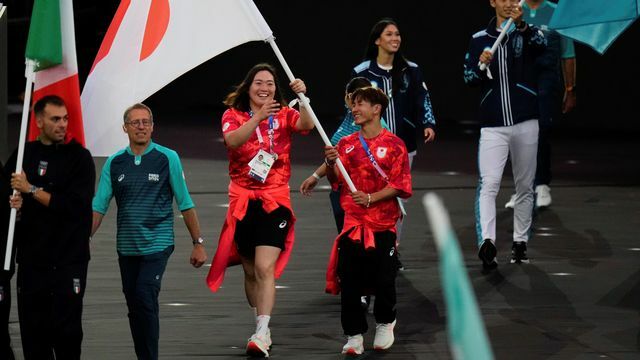 パリ五輪閉幕式で日本選手団の旗手を務めた北口榛花選手と半井重幸選手(写真：AP/アフロ)