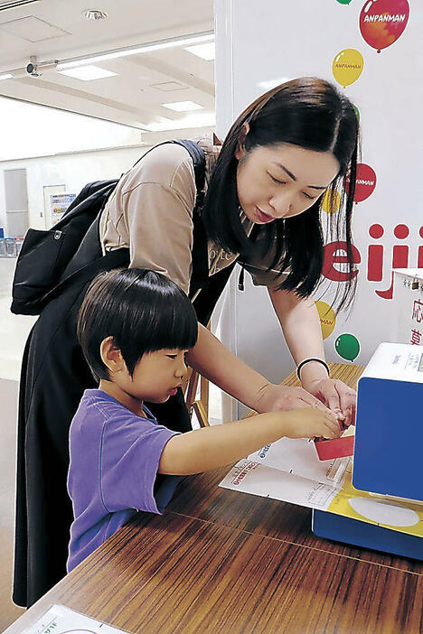 台紙にスタンプを押す親子=小松空港