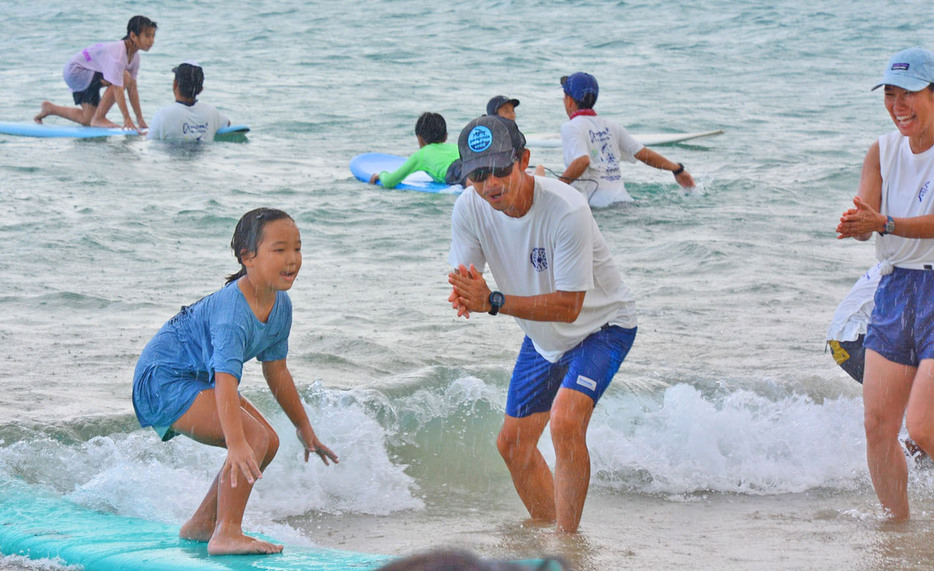 島内外の児童生徒が海について学び、波乗りを楽しんだサーフィンイベント＝25日、鹿児島県龍郷町赤尾木