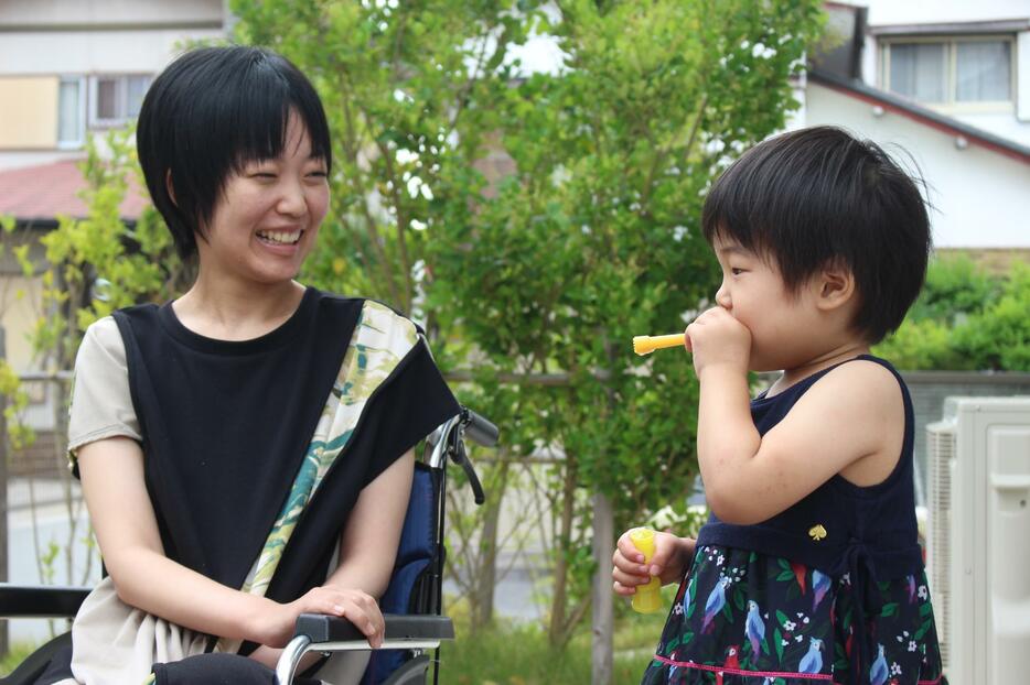 シャボン玉で遊ぶALS患者のみみりんさん（仮名、左）と長女（右）＝2024年6月、愛知県