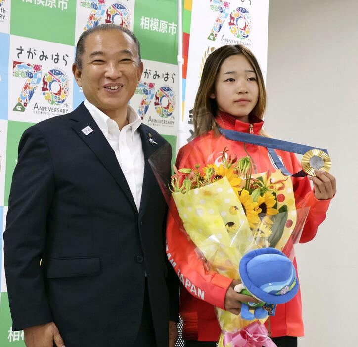 相模原市の本村賢太郎市長（左）と写真に納まるパリ五輪スケートボード女子ストリートで金メダルの吉沢恋＝3日午前、相模原市