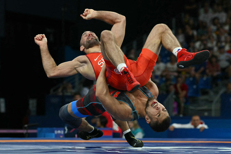 パリ五輪、レスリング男子グレコローマンスタイル67キロ級敗者復活2回戦。対戦するセルビアのマテ・ネメシュ（上）とキルギスのアマントゥール・イスマイロフ（2024年8月8日撮影）。