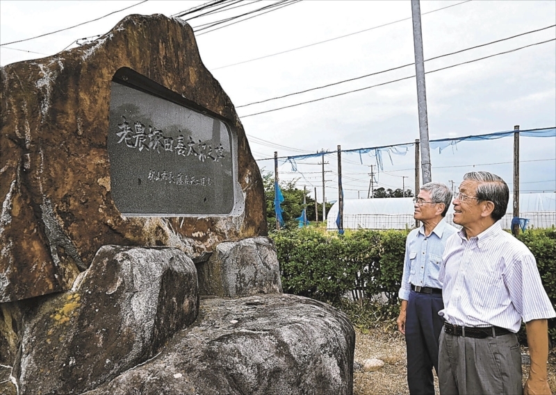 郡山市にある顕彰碑に偉人の功績発信を誓う大内さん（右）と金田さん