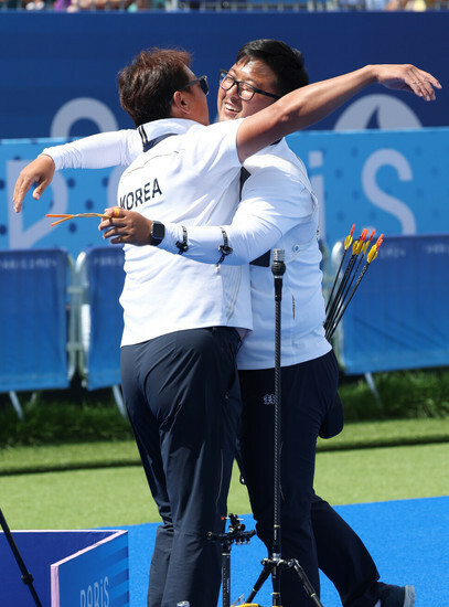 4日（現地時間）、フランス・パリのアンバリッドで開かれた2024パリ五輪アーチェリー男子個人決勝の米国ブレイディ・エリソンとの試合で、キム・ウジンが金メダルが確定した後、パク・ソンス監督と抱き合っている=パリ/カン・チャングァン先任記者