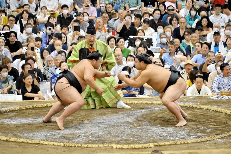 大勢の観客の声援を受け、明生と対戦する若元春（右）