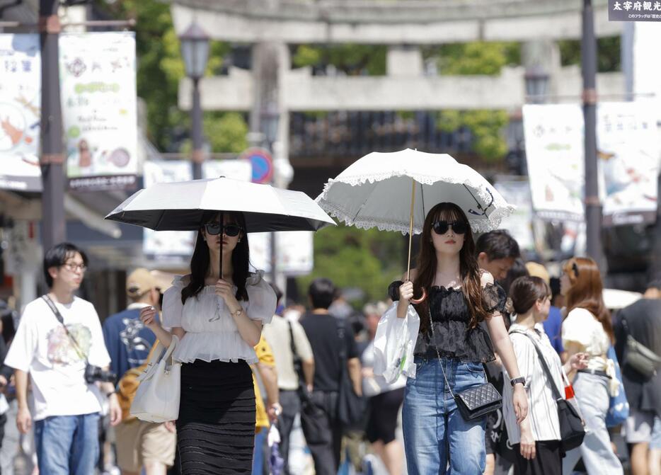 猛暑日が続く福岡県太宰府市で日傘を差して歩く人たち＝23日