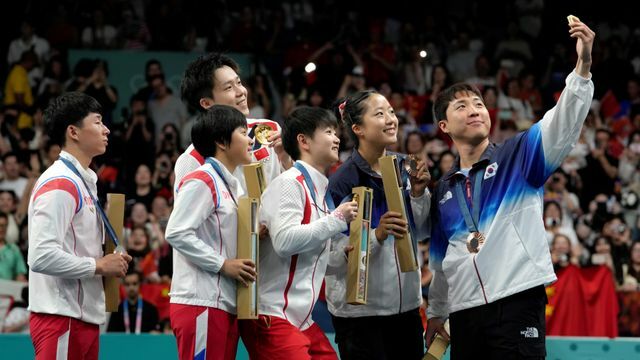 卓球混合ダブルスの表彰式で自撮りをするメダリストたち(写真：AP/アフロ)