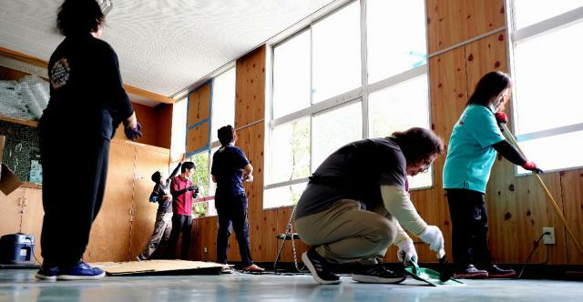 窓ガラスが割れる被害があった宮崎市の小戸小。教員らが段ボールでふさいだり、ガラス片を片付けたりしていた＝３０日午前１１時５分