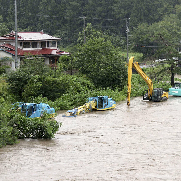 8月12日、岩手県岩泉町を流れる小本川が台風5号の影響で増水し、工事車両が水に漬かった（写真・共同通信）