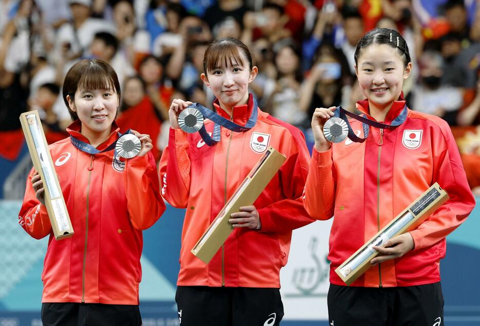 パリ五輪の卓球女子団体で銀メダルを獲得し、表彰台で笑顔の（左から）平野美宇、早田ひな、張本美和＝10日、パリ（共同）