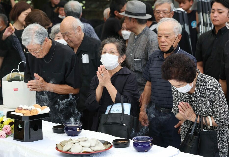 慰霊祭で、小桜の塔に向かい、手を合わせる参列者たち＝22日、那覇市（小川昌宏撮影）