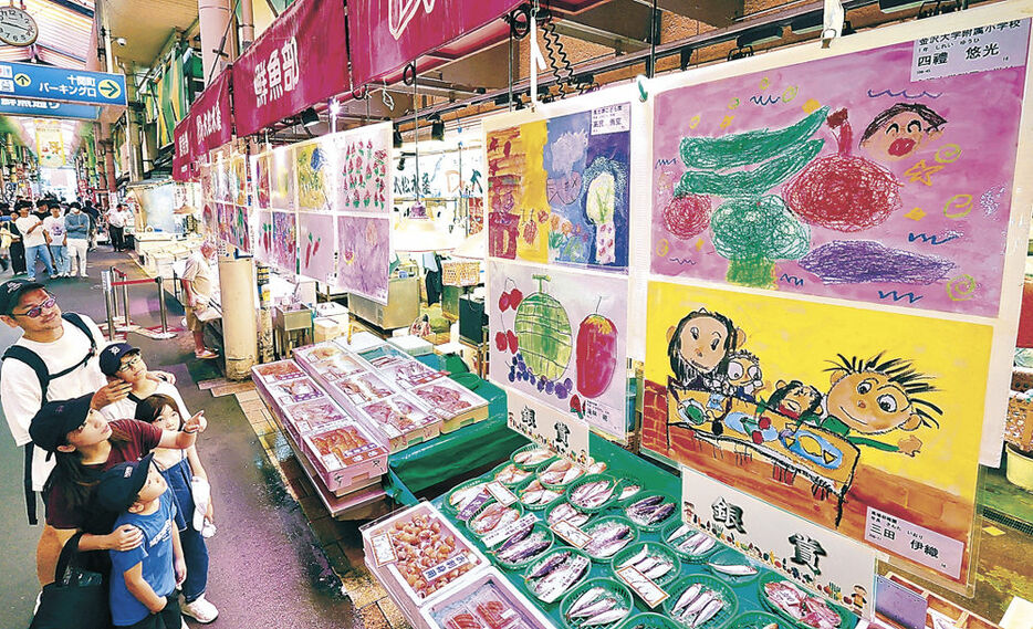 市場の店先を飾る子どもたちの絵画＝２２日午前９時半、金沢市の近江町市場