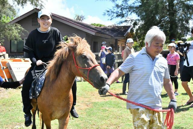 乗馬体験に笑顔を見せる参加者＝2日、市下地の宮古島熱帯果樹園まいぱり