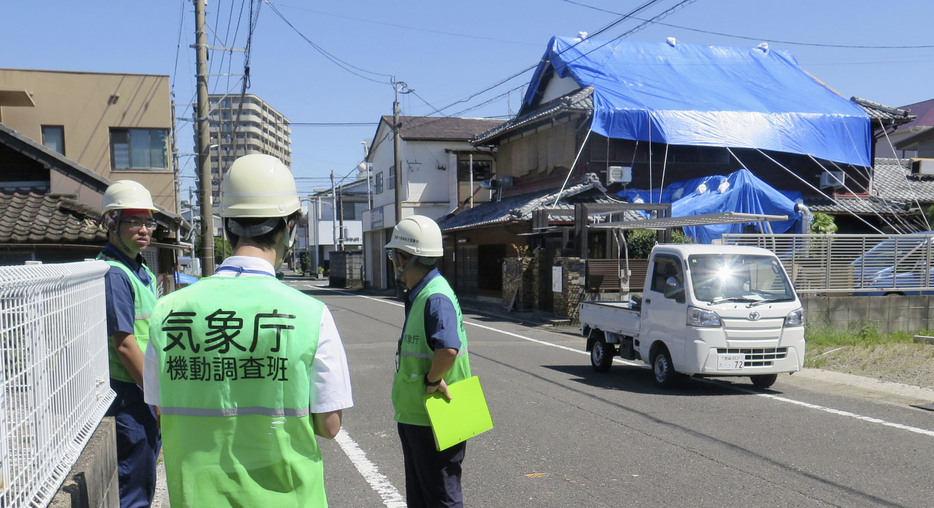 突風による被害を受けた現場を調べる気象庁の担当者＝31日午前10時51分、宮崎市