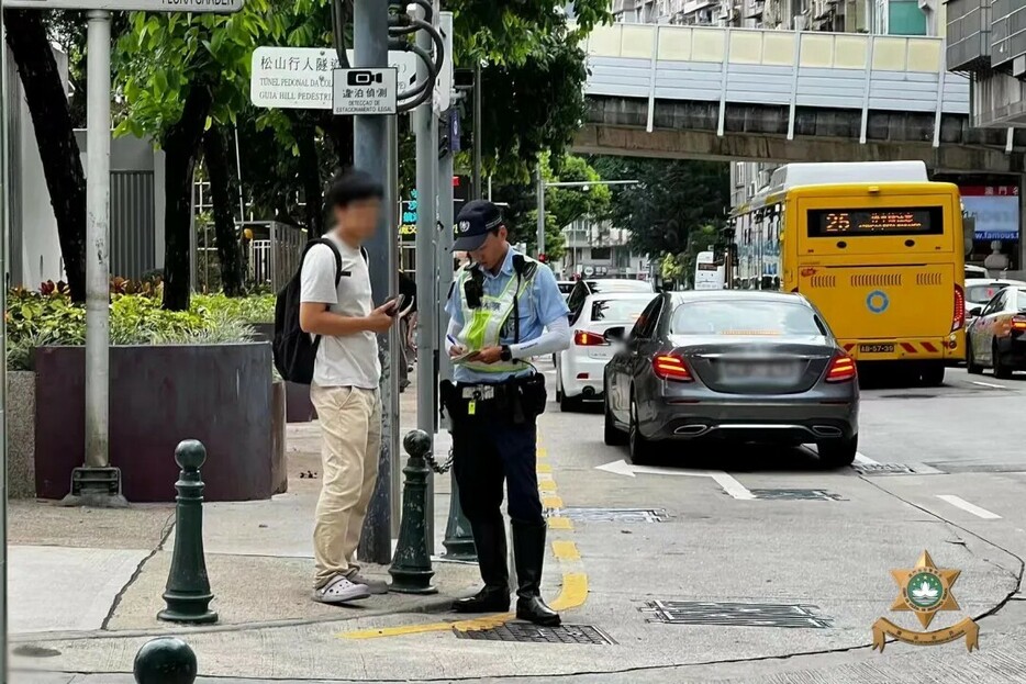 マカオ治安警察局が実施した歩行者の道路横断違反に対する取り締まりの様子＝マカオ半島・二龍喉公園前（写真：マカオ治安警察局）