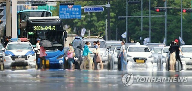 強い日差しが照りつけ、かげろうが立ちのぼるソウル市内の道路＝（聯合ニュース）