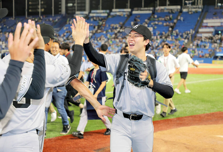 今季９勝目を挙げ、中継ぎ陣とタッチを交わす山崎伊織（カメラ・相川　和寛）