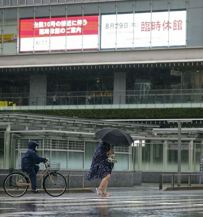 風雨が強くなる中、JR博多駅前を歩く人＝29日午後2時8分