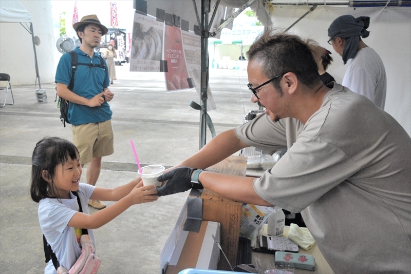 来場者に「いちごミルク」を手渡す斎藤さん