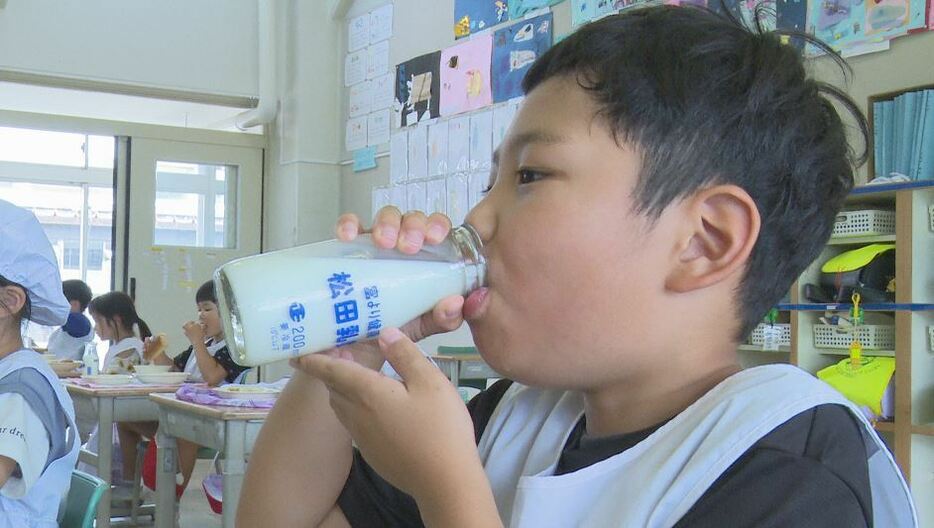 最後の瓶牛乳を飲む児童