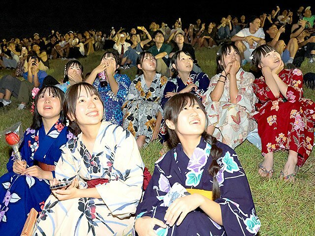 鮮やかな花火を見上げる観客