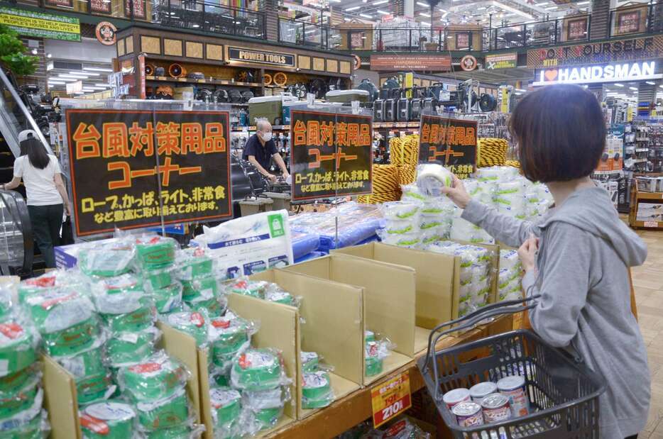 台風対策用品コーナーで品物を手に取る客＝２６日午後、鹿児島市宇宿２丁目のハンズマン宇宿店