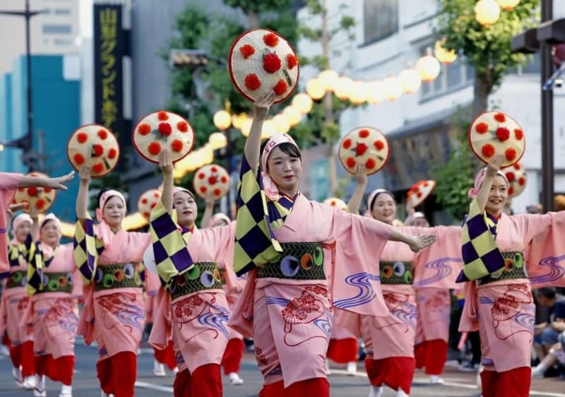 「山形花笠まつり」で紅花をあしらった花笠を手に舞を披露する踊り手＝５日夕、山形市