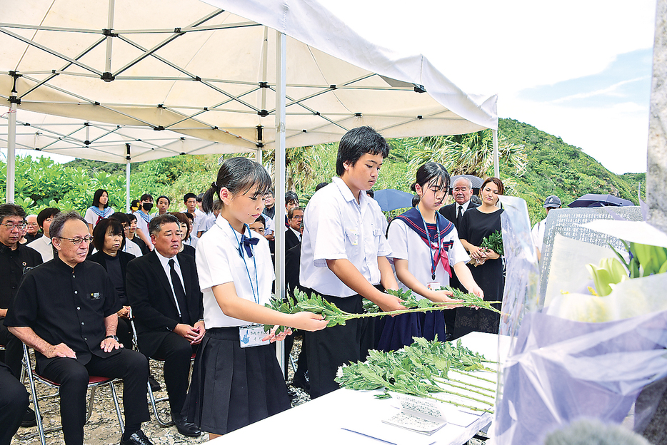 船越海岸の慰霊碑に献花する奄美・沖縄の児童生徒＝24日、鹿児島県宇検村