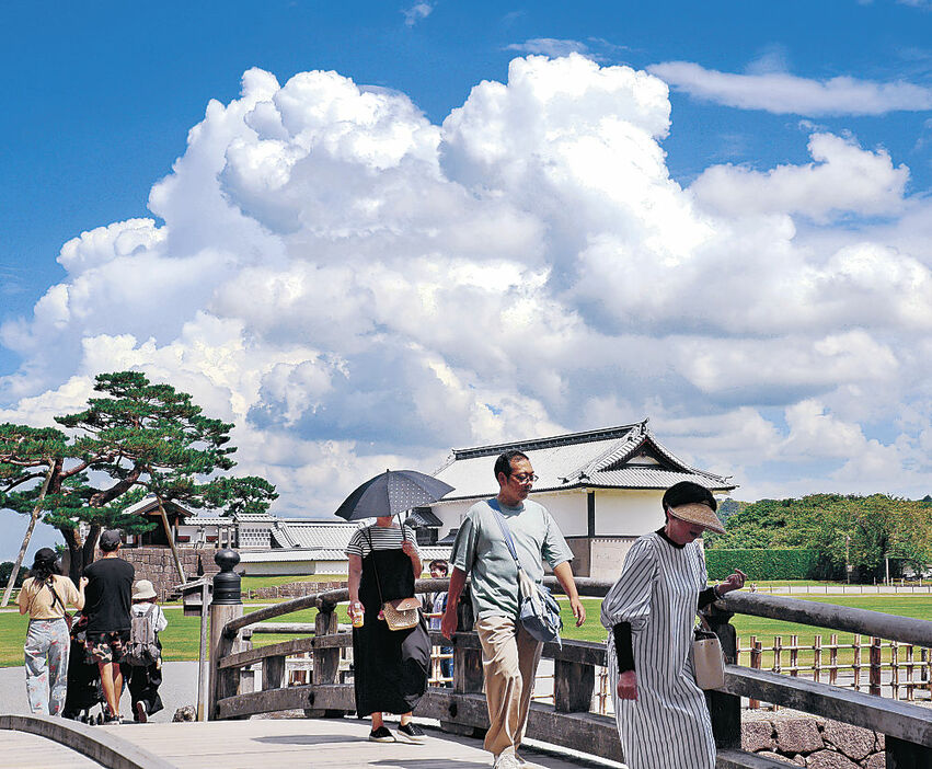 強い日差しが降り注ぐ中、園内を散策する観光客＝２６日午前１１時半、金沢城公園