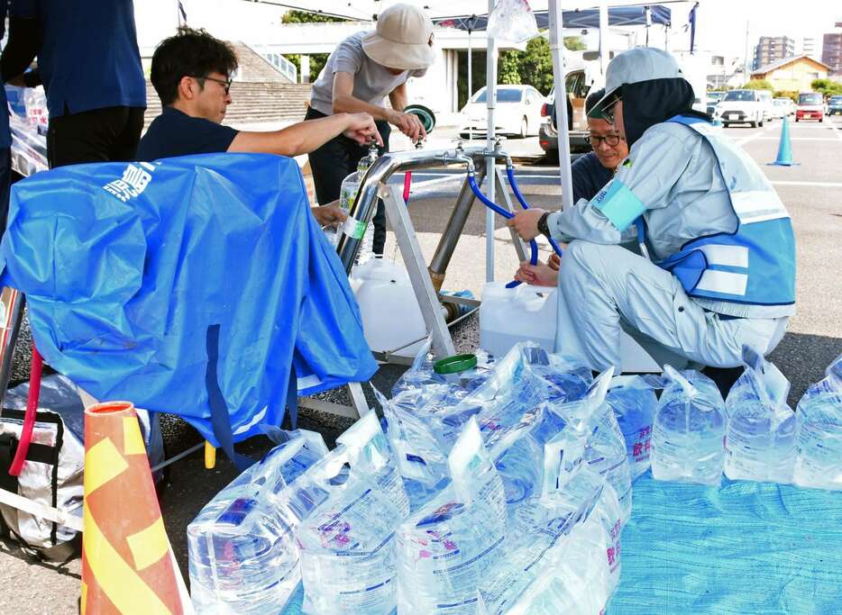 給水車で容器に水を受け取る市民＝１０日、霧島市役所お祭り広場駐車場