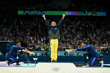 パリ五輪、体操女子種目別ゆか。表彰式で金メダルを獲得したブラジルのレベッカ・アンドラーデ（中央）をたたえる米国のシモーネ・バイルス（左）とジョーダン・チャイルズ（2024年8月5日撮影）。