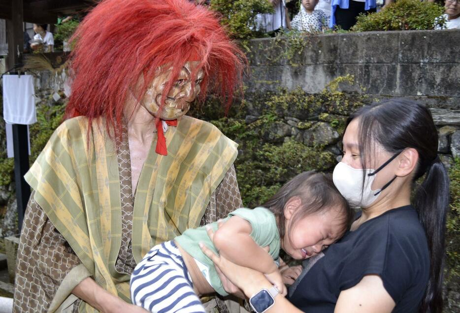 「椎出鬼の舞」で鬼に威嚇され、怖がって泣き叫ぶ子ども＝16日午後、和歌山県九度山町