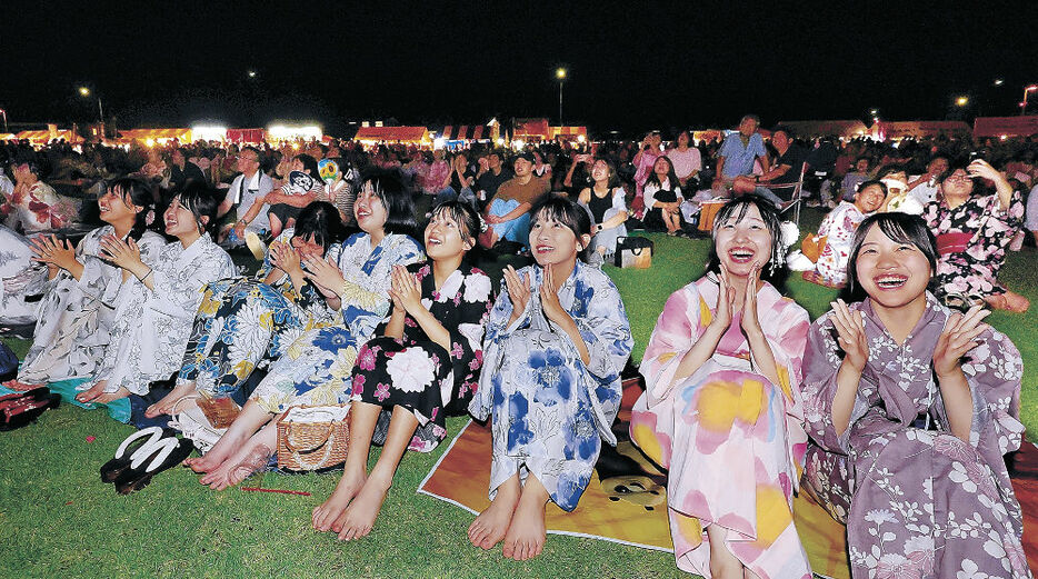 夜空を彩る花火に見入る観客＝３日午後８時１０分、氷見市の比美乃江公園