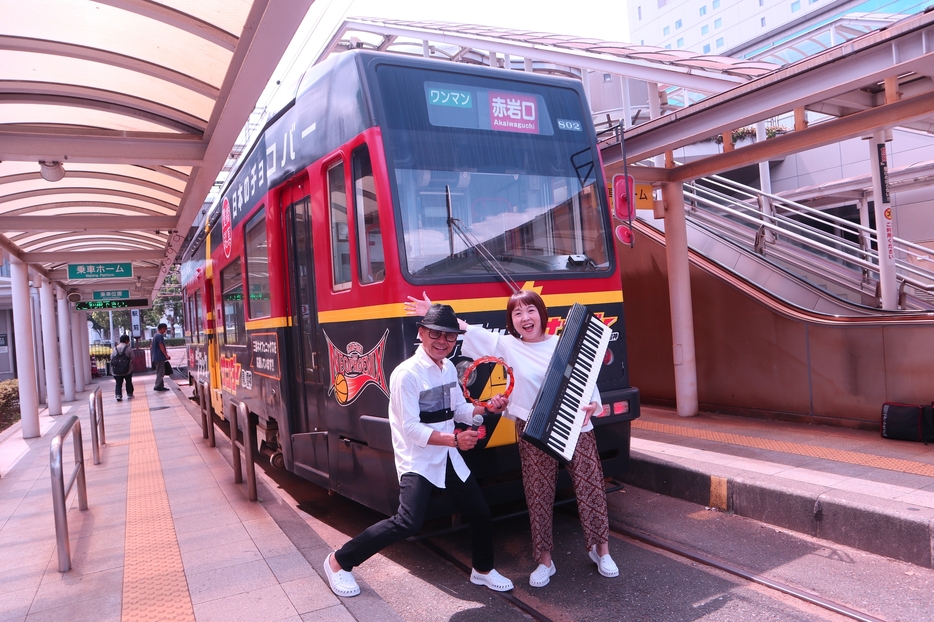 ブラックサンダー号の前で歌声電車をPRする琳佳さんと松さん=駅前電停で