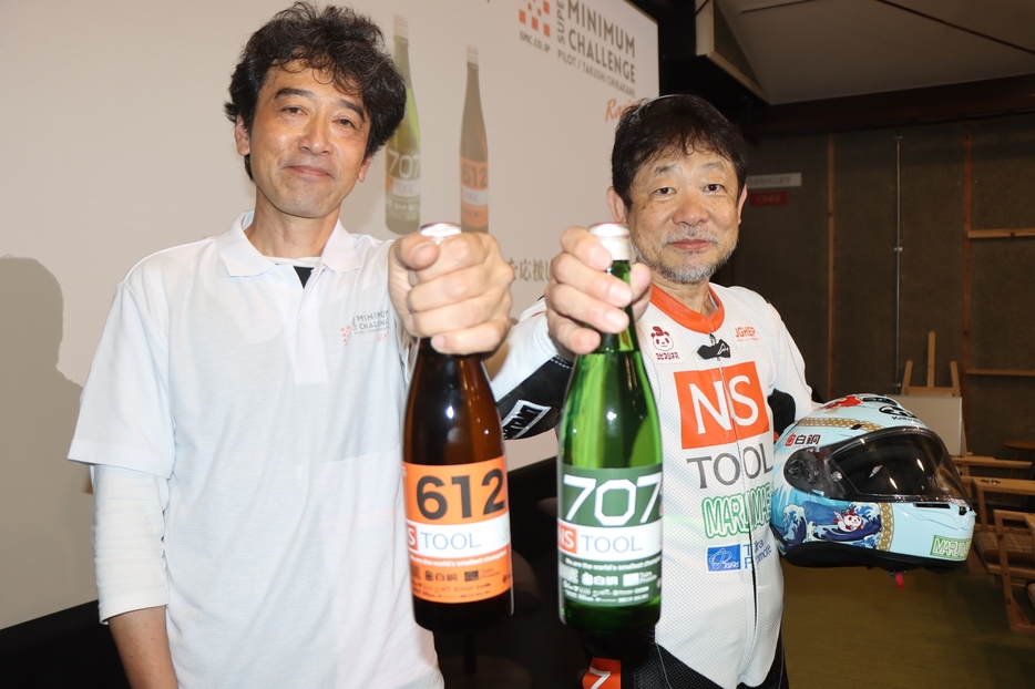 世界最速記録更新を応援したいと販売した日本酒を手にする荻野さん（左）とライダーの近兼さん＝兵庫県丹波市氷上町成松で