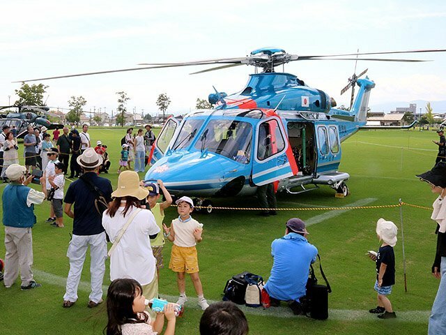 地上で展示される県警ヘリ「つるぎ」に見入る来場者＝クロスランドおやべ