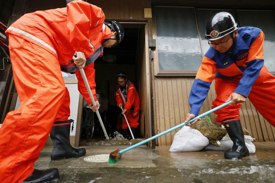 大雨で浸水した岐阜県大垣市の住宅から水をかき出す消防団員ら＝31日午後4時25分