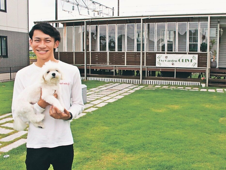 ドッグガーデン「オリーブ」で自身の愛犬を抱く梅本社長