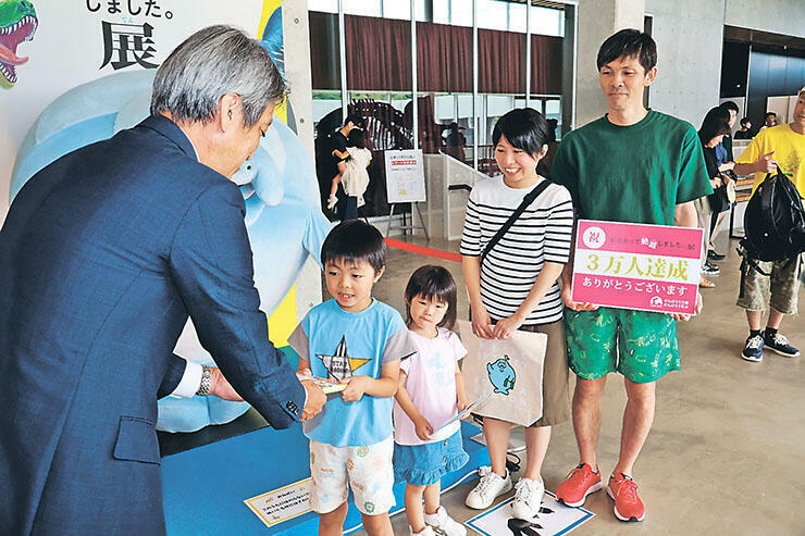 3万人目の来場者となった石崎奏汰さん（左から2人目）と家族ら=氷見市芸術文化館