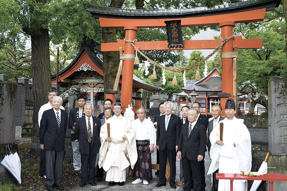 解体される鳥居の前で記念撮影をする参列者