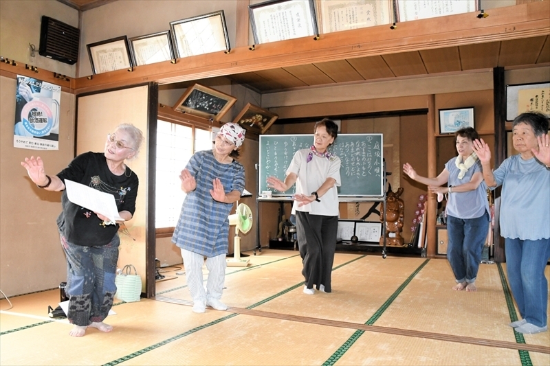 作田会長（左）から庭坂小唄の指導を受ける佐藤さん（左から２人目）ら