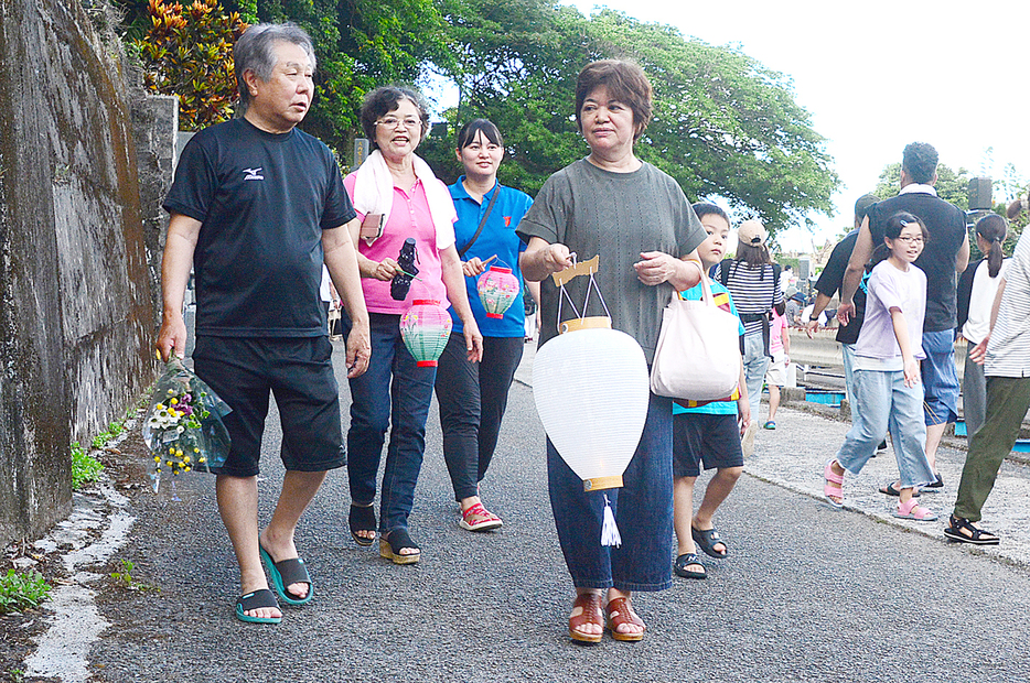 ちょうちんを手に墓参りに訪れる人々＝18日、鹿児島県奄美市名瀬の永田墓地